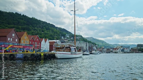 Sailboat and Bryggen waterfront buildings in Bergen. Scenic harbour and maritime culture in Norway.