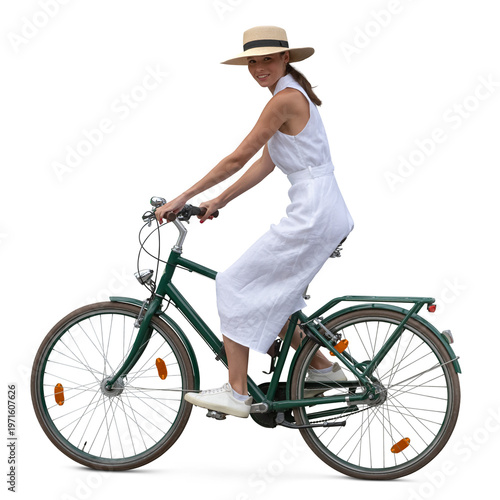 Quadro su tela Woman in a white dress and wearing a hat riding a bicycle seen from side view, i