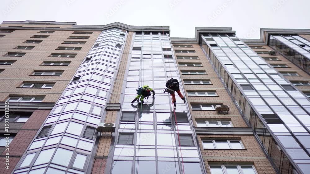 Window Cleaner In Building Window cleaners work on the glass facade of a modern skyscraper ...