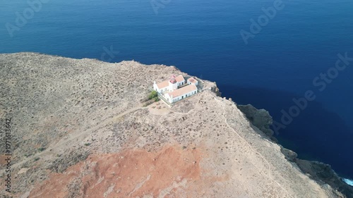 Aerial drone view over a rocky tiny island (Ilheu) with a light house. Volcanic scenic view in Porto Santo island, Madeira, Portugal