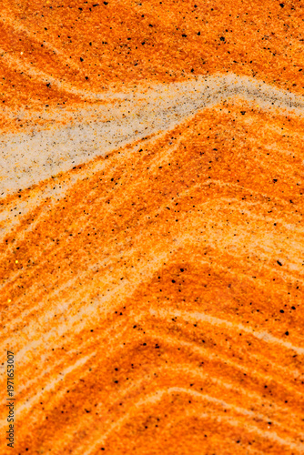 Abstract view swirling orange and white sand layers. Dynamic curves creating natural, marble like sand texture.