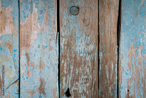 Close-up of weathered blue painted wooden planks with peeling layers, cracks and aged texture. Rustic surface ideal for vintage backgrounds and design use.