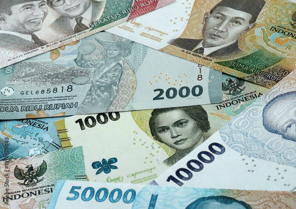 Fototapeta premium Indonesian rupiah money banknotes pile on table. Indonesia bills of IDR currency close up
