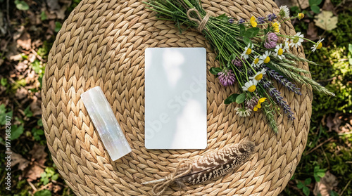 Blank tarot card for mockup template on wicker surface with selenite crystal, wildflowers bouquet and feather, boho spiritual flat lay