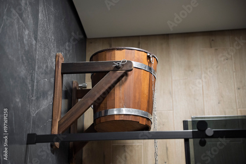 Foto Traditional wooden sauna dousing bucket mounted on a wall