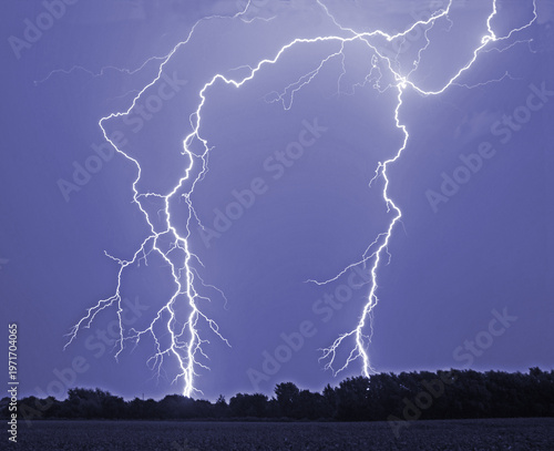 Lightening over North Yorkshire showing forks of lightening striking the ground with the flash illuminating the clouds
