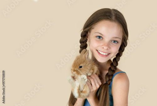 Happy little child girl with cute rabbit. Portrait of kid with pet.