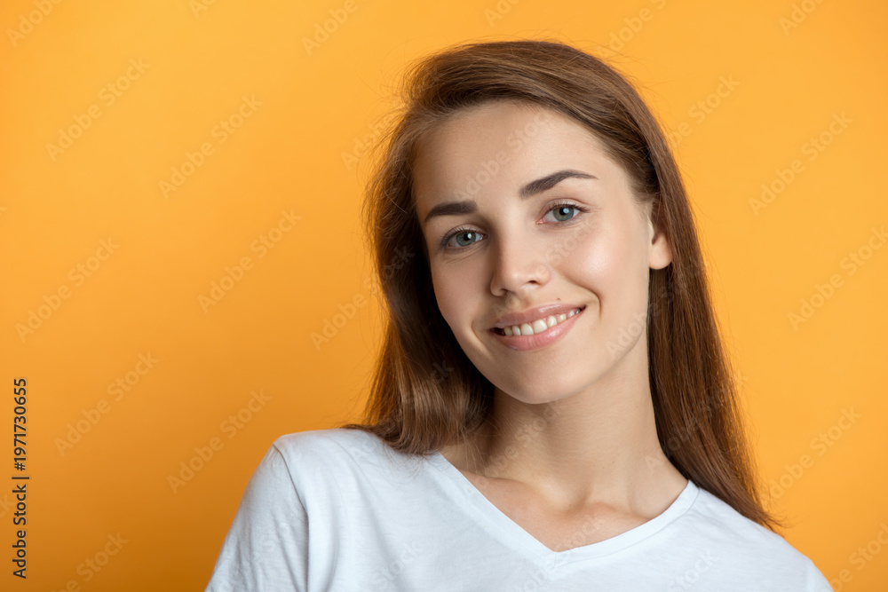 Obraz premium Beautiful young smiling woman with clean perfect fresh skin and white teeth smile. Portrait of beauty model girl with natural make up, formed eyebrows and long eyelashes. Spa, skincare and wellness