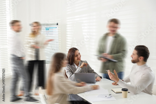 Fotografie Colleagues working indoors, motion blur effect
