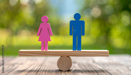 Pink and blue figurines on wooden seesaw symbolizing gender equality and balance.