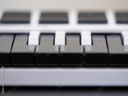 Close -up view of black and white midi keyboard keys for music creator. Selective focus.