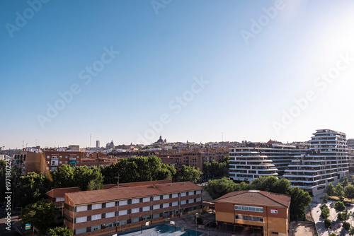 scenic view of modern apartment buildings in Arganzuela District , traditional residential blocks, and lush green trees in Madrid, Spain
