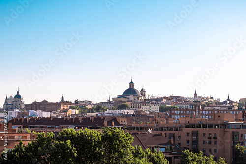 A scenic, elevated view of the Madrid city skyline in Spain featuring the Almudena Cathedral and the Royal Basilica of Saint Francis the Great during the daytime