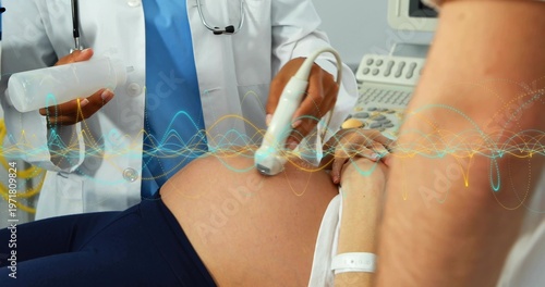 Schilderij op canvas Scanning doctor in white coat holding ultrasound probe on pregnant belly at clin