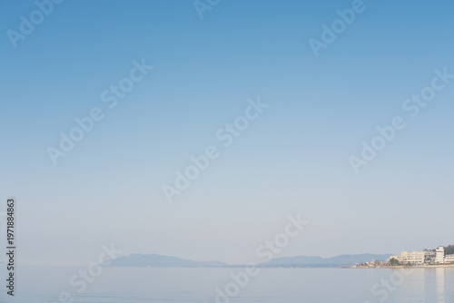 穏やかな湖辺の街並み、青空と山並みが織りなす風景