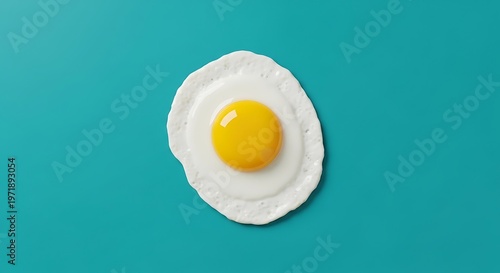 Sunny-side-up fried egg on a vibrant teal background, culinary delight, breakfast food.