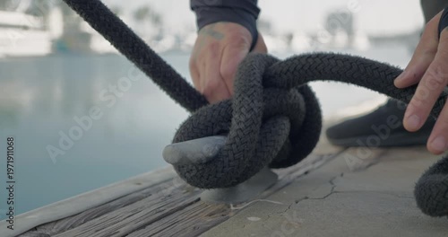 Technician Securing Boat Rope at Dockside