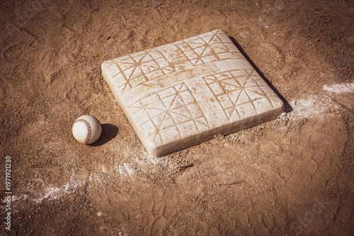Baseball and base on dirt sports field