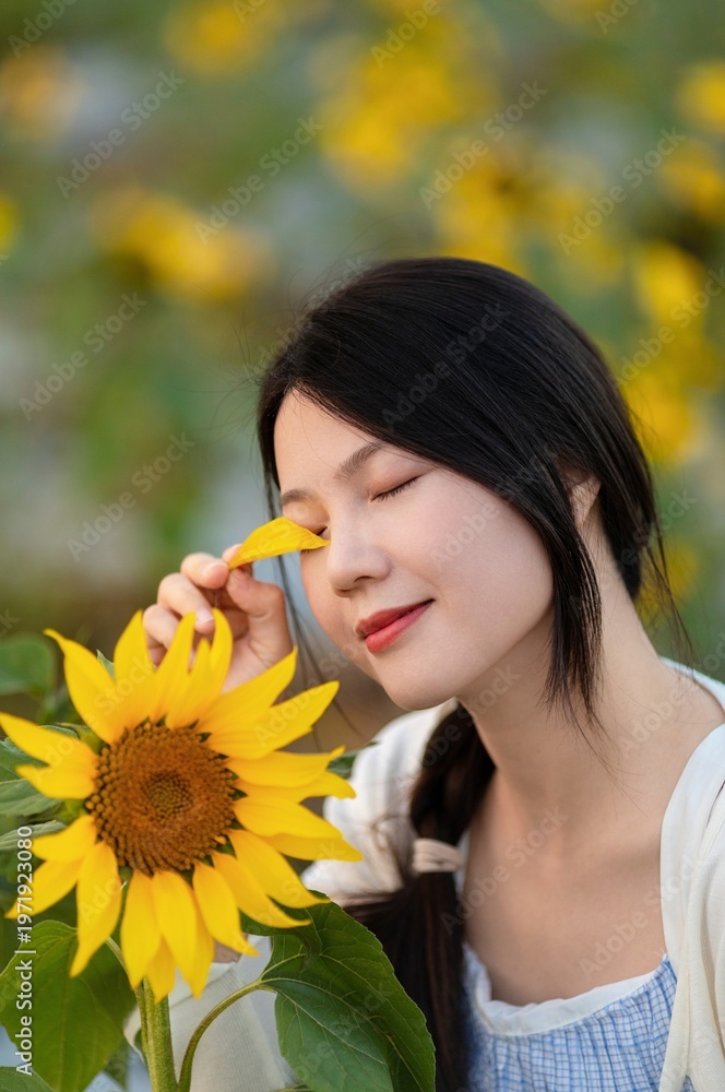 Naklejka premium Asian beauty in a sunflower field