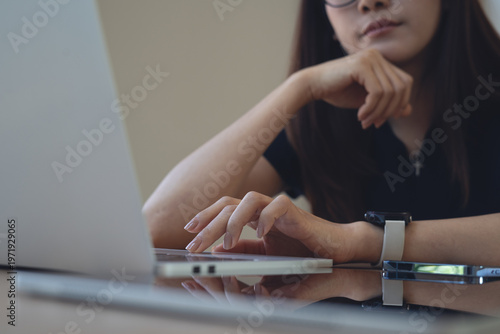 Fotografia Close-up of tired woman using laptop at home office, pensive remote worker in soft natural light