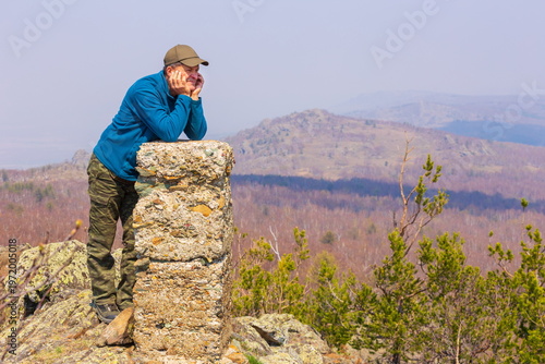 portrait of a mature male tourist on top of a mountain range