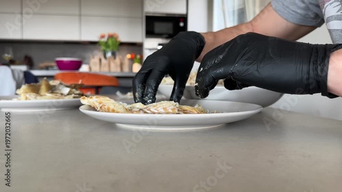 Midsection of man cleaning the bones of cooked cod