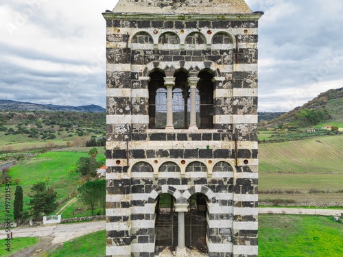 Romanesque arched windows and columns on striped bell tower of Basilica di Saccargia. Codrongianos, Sardinia, Italy