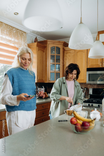 Foto In a warm, inviting kitchen filled with wooden cabinets, two friends share a joyful moment