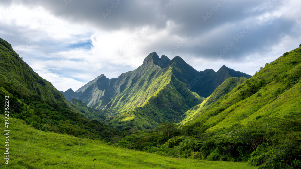 Fototapeta premium Lush green mountains under a cloudy sky with sunlight casting shadows on the peaks and valleys in a tranquil natural landscape.