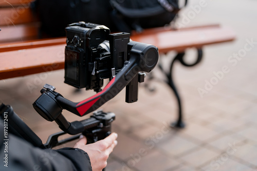 Quadro em tela Professional camera on motorized gimbal held by operator near urban bench, illus