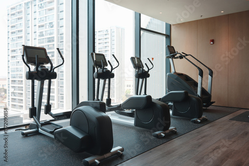 Bilde på lerret Modern fitness center with multiple elliptical trainers lined up beside large fl