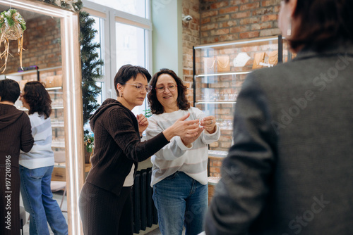 Fotografie Two friends share a joyful moment while exploring a jewelry boutique