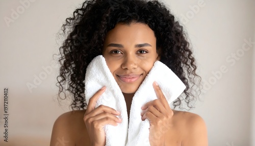 Woman gently drying face with soft towel, natural skincare and fresh skin concept