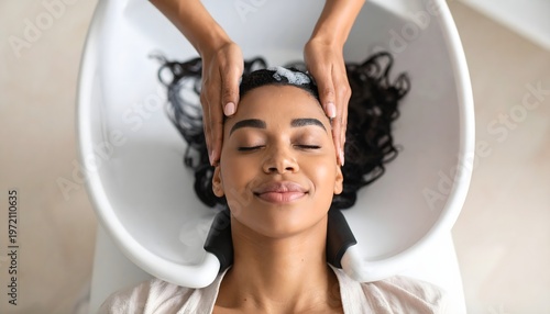 Woman enjoying relaxing hair wash at salon basin with scalp massage, top view close-up