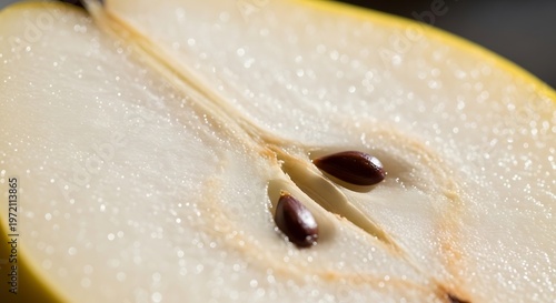 Extreme close-up of a sliced pear half revealing seeds and juicy flesh texture with cut fruit