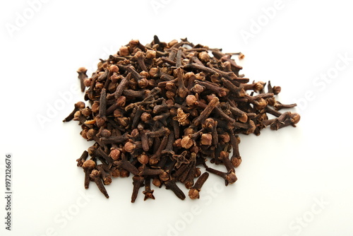 Dried clove buds piled on a white background for culinary and medicinal use