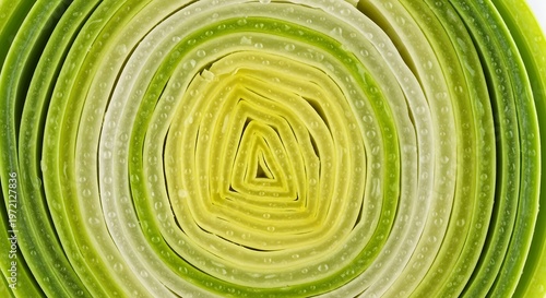 Detailed close-up of a freshly cut leek cross-section revealing its intricate concentric green and yellow layers with spring onion
