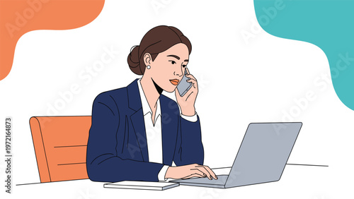 Professional business woman in a dark blue suit works at her desk while talking on a smartphone and typing on a laptop computer.