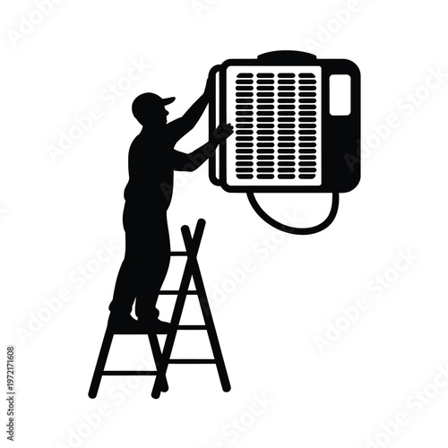 Silhouette of a technician installing an air conditioning unit outdoors