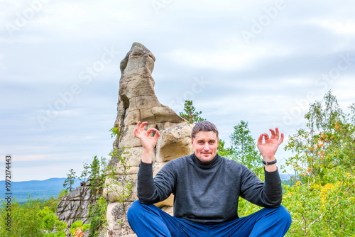 young handsome man on a rock on the Arakul shihan enjoys on a summer day