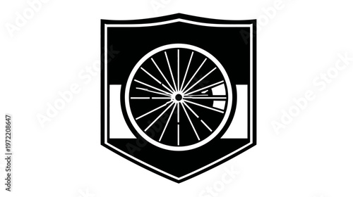 A black and white shield design featuring a spoked wheel, enclosed within the shield shape