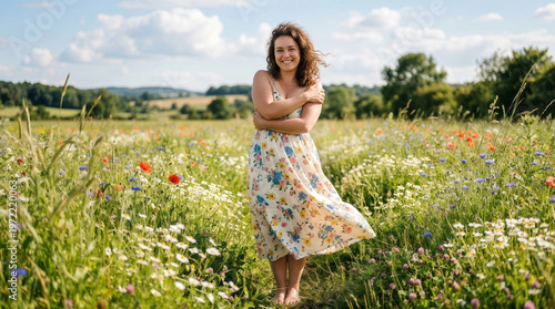 Young woman in floral dress walking joyfully through wildflower meadow on sunny day