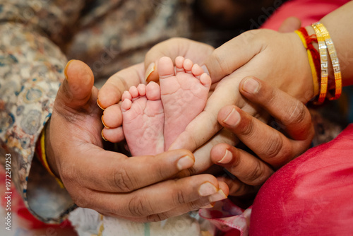 Fotografie A loving couple gently holding their newborn baby's tiny feet together