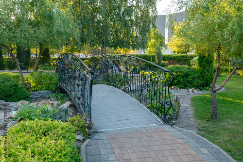 Voronezh, Russia, September 5, 2025: A decorative bridge with iron railings in Victory Park in early autumn.