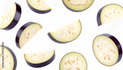 Assortment of fresh eggplant slices in various orientations on a white backdrop
