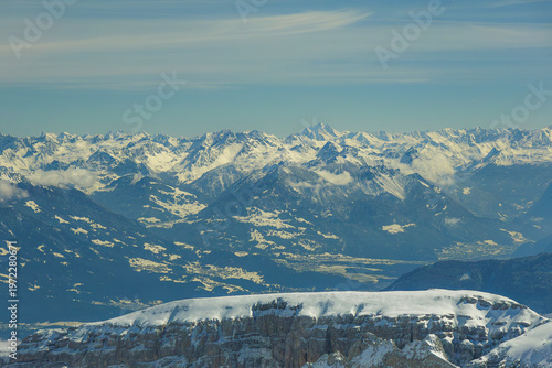 Snow covered mountain range with clear blue sky and distant peaks. landscape showcases rugged terrain and serene beauty, perfect for winter adventures and nature enthusiasts