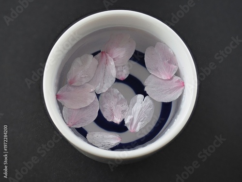 Tokyo, Japan - April 1, 2026: Closeup of Sakura cherry blossom petals in Sake cup

