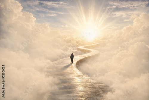 Silhouette of a man walking on winding path through the clouds, ending at a brilliant light in the distance. It symbolises heaven, afterlife, a near-death experience, path to a goal and bright future.