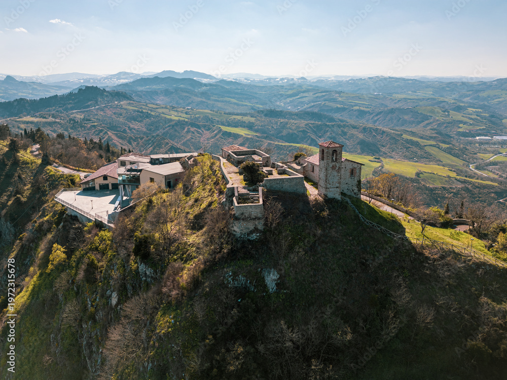 Fototapeta premium Aerial drone view of Torriana Two Towers Castle, Emilia-Romagna, Italy – dramatic hilltop fortress with medieval ruins and panoramic countryside landscape
