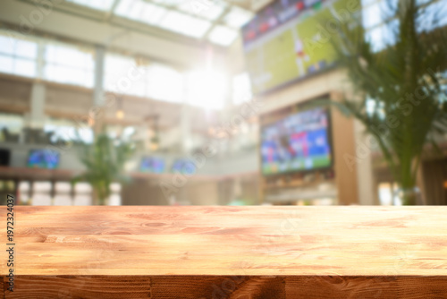Tableau sur toile wooden table on foreground and blurred background depicts the lively interior of